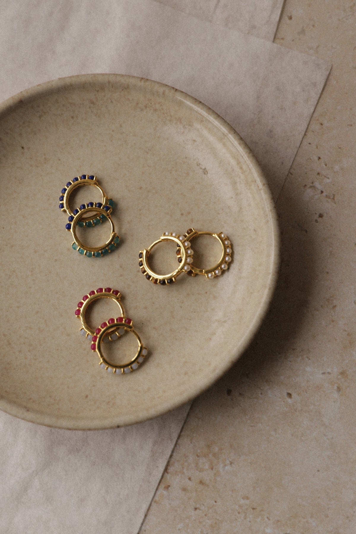 DELTA reversible gemstone huggies in a stoneware dish