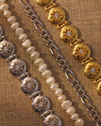 Mixed metal bracelet stack with gold, silver, pearl and chain bracelets layered together