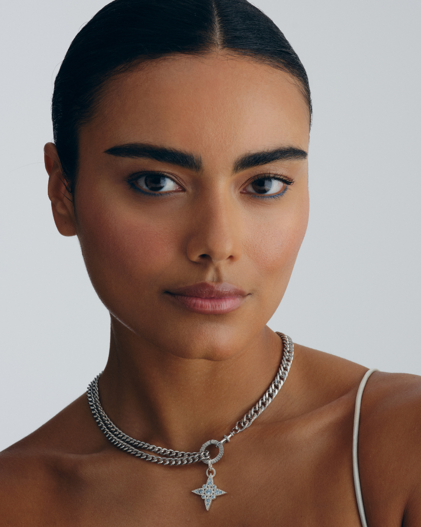 Layered silver jewellery set with chain necklace, bracelet, and star pendant showing multiway styling and connection worn by a model