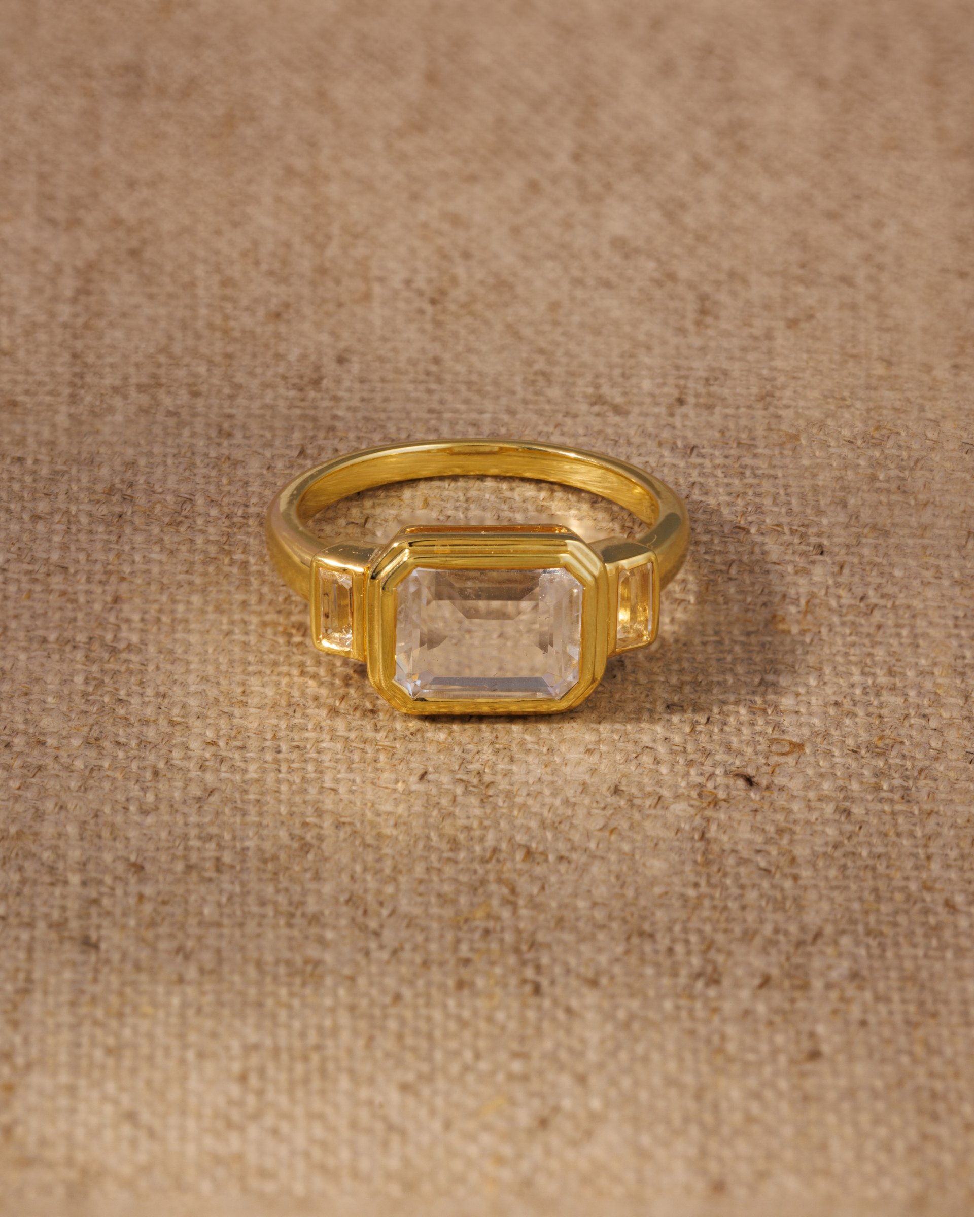 Clear quartz emerald cut ring in gold vermeil bezel setting with baguette side stones