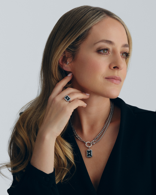 Fleur de Force wearing a silver chain necklace, chain bracelet, onyx pendant