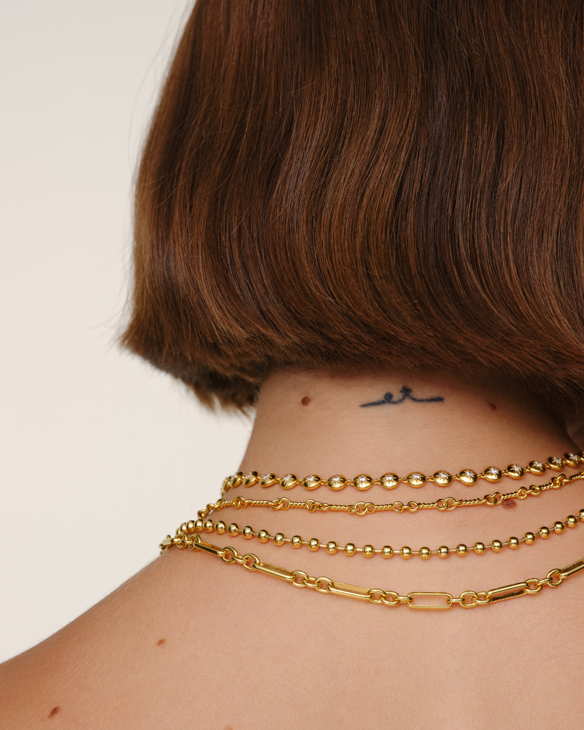 Layered gold jewellery featuring the Lulu tennischain, Arabella necklace and Claudia necklace. Designed to be worn together to build a personalised jewellery stack.