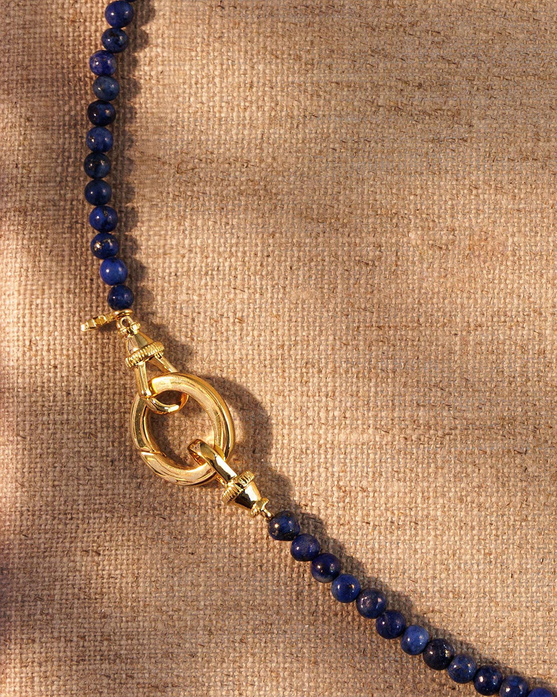 Close-up of lapis beads with gold clasp and oval ring