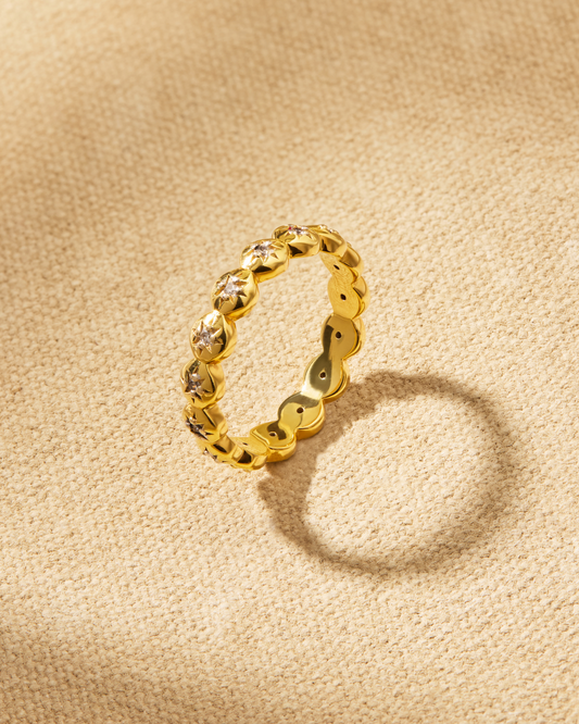 Ines gold stacking ring with star detailing and crystals around the band