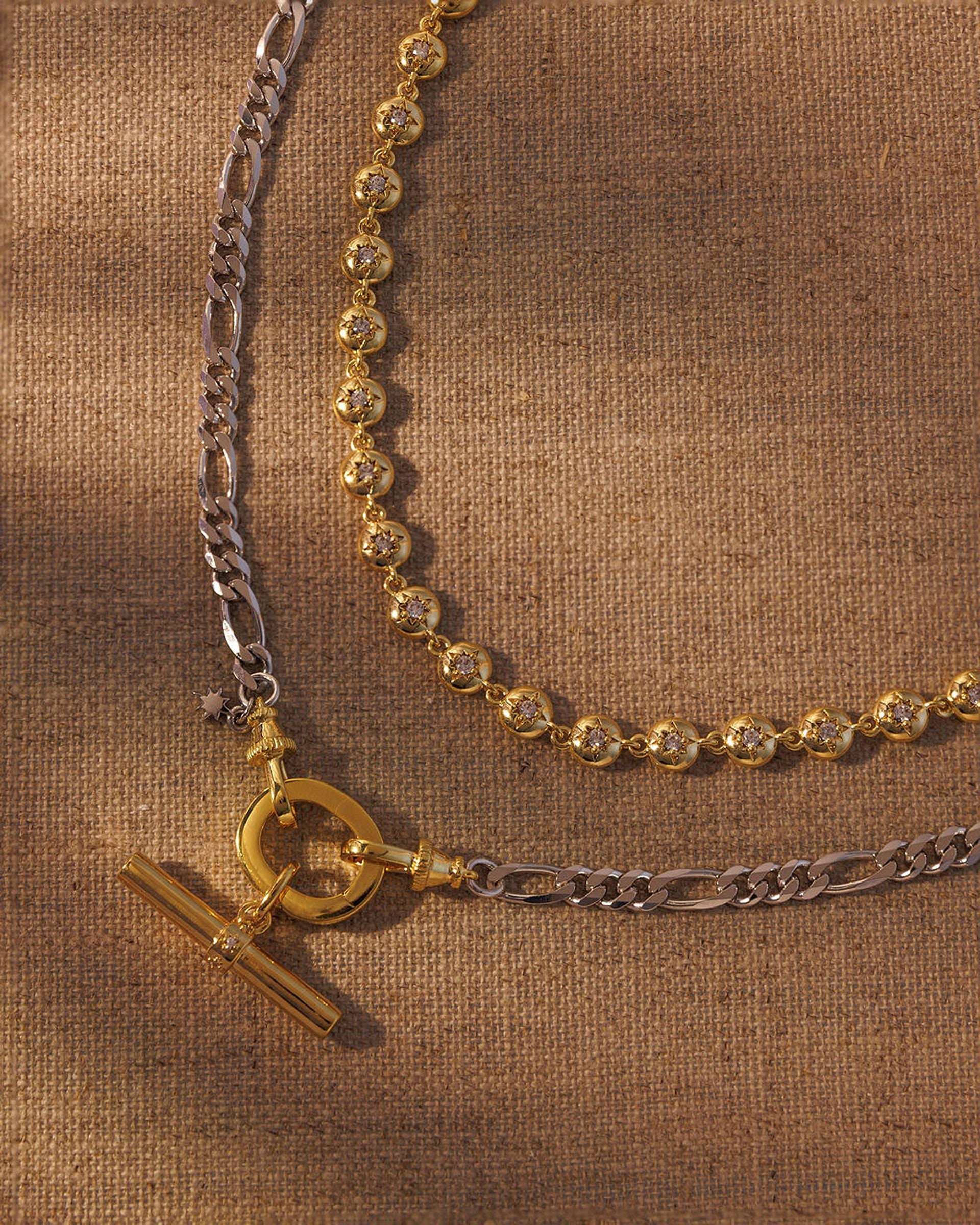 Layered gold and silver necklace set with T-bar pendant and crystal link chain