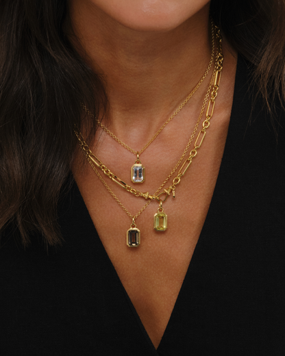 Layered gold vermeil necklaces with clear quartz pendant on Ivy chain, lemon quartz pendant on Tabitha chain, and smoky quartz pendant on Ivy chain