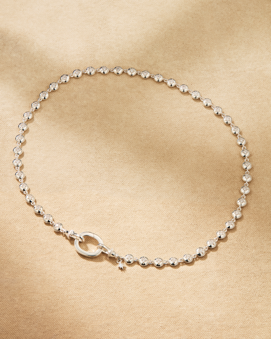 A silver tennis necklace set with clear crystals. Designed to wear alone or layer with chains for a more styled look.