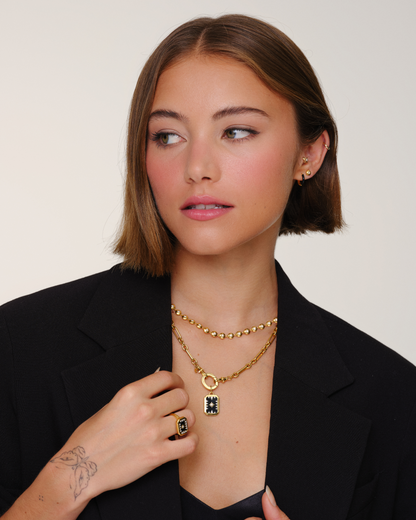 Model wearing layered gold necklaces with Tabitha chain, Lulu bead necklace and Talisman black onyx pendant styled together