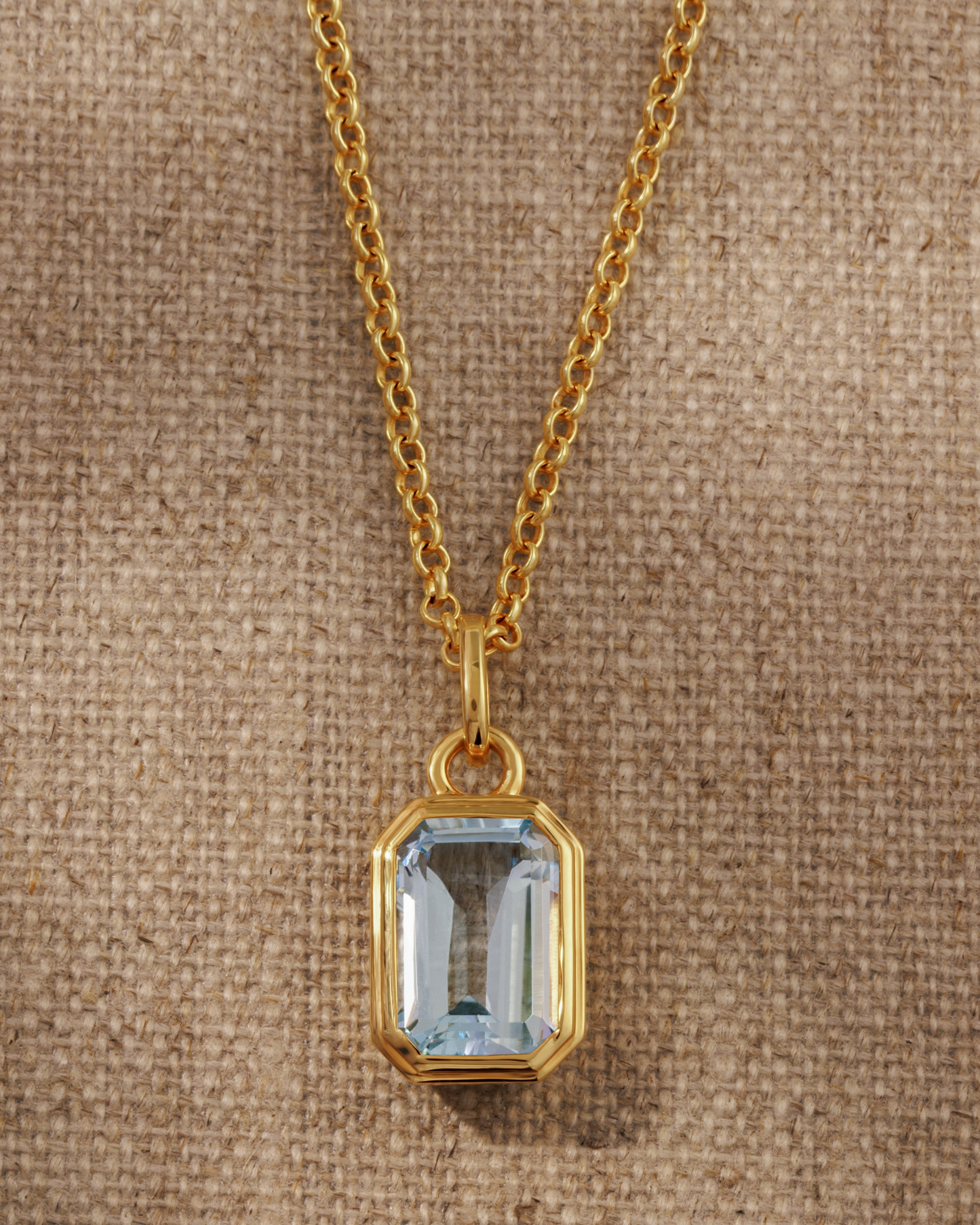 Lumi 18ct gold plated emerald cut blue topaz pendant on an Ivy gold chain necklace