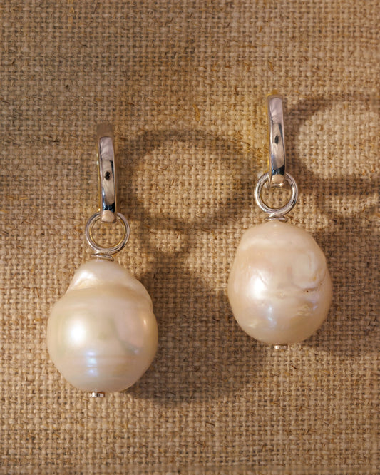 Reversible silver huggies with baroque pearl charms. Two hoops, two finishes, endless ways to style. Demi-fine, made to layer.