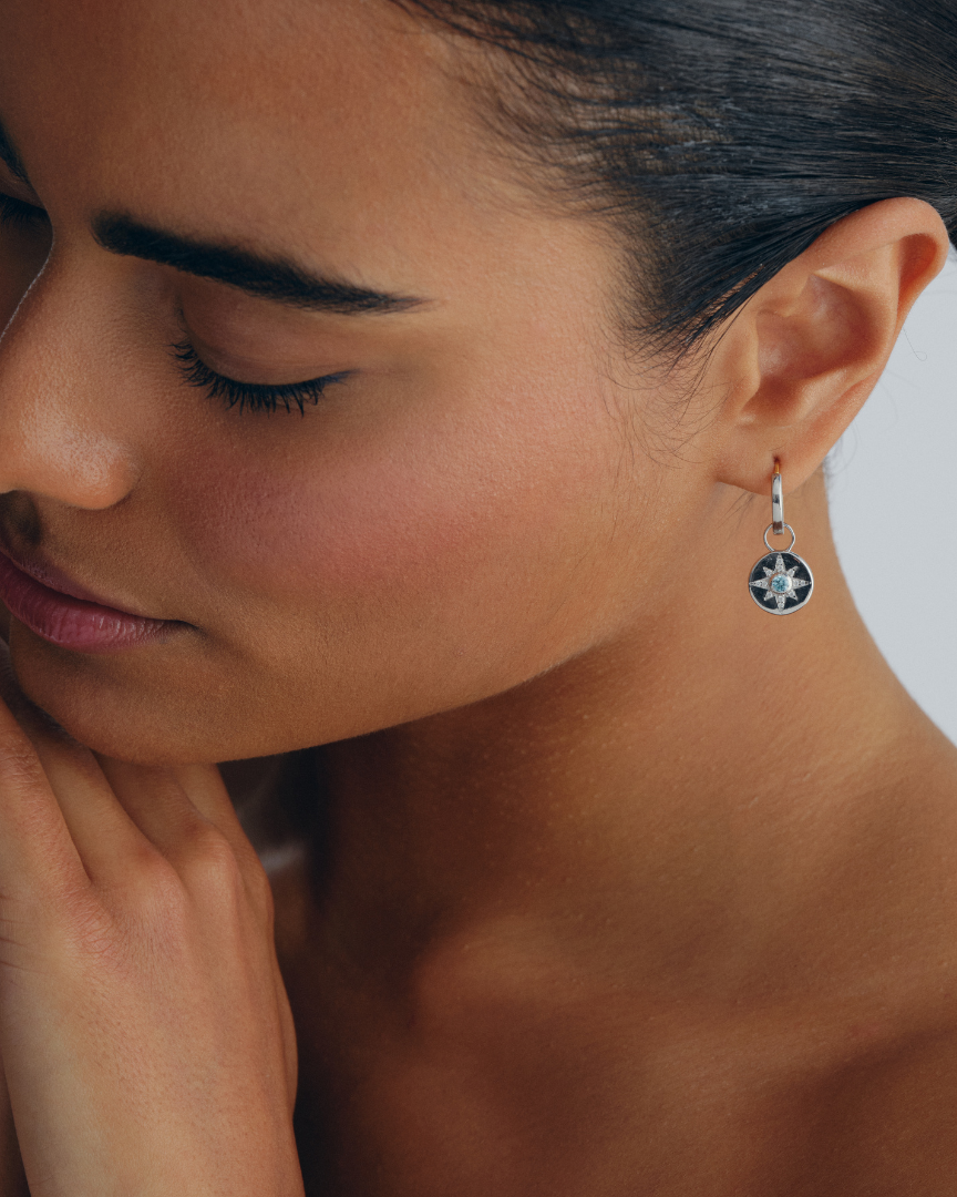 Vega earring charms in sterling silver with star design and aquamarine crystals worn on huggie hoop earrings