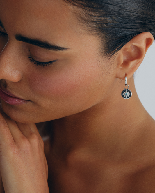 Vega earring charms in sterling silver with star design and aquamarine crystals worn on huggie hoop earrings