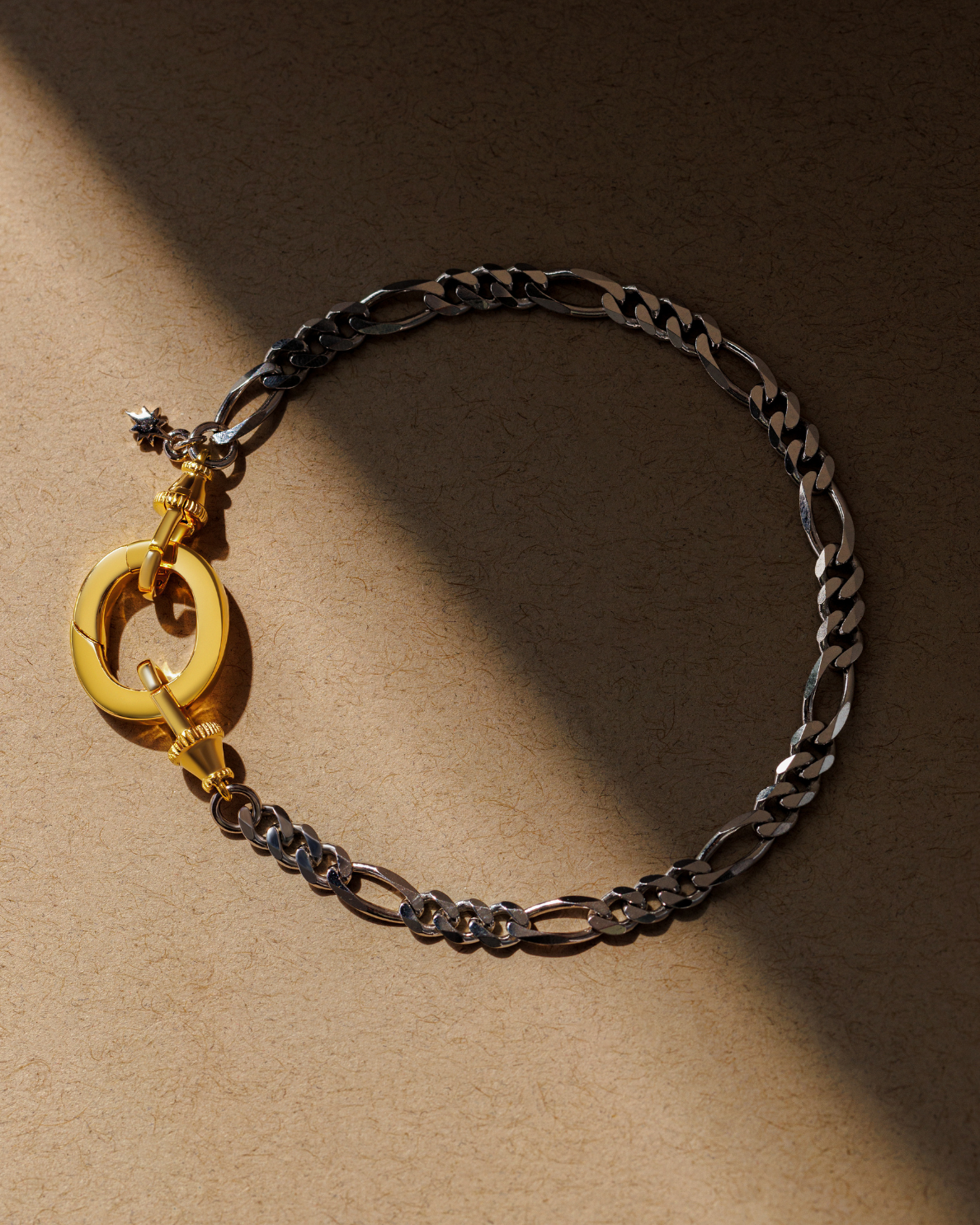Mixed metal figaro chain bracelet with gold oval clasp and dual lobster clasps in silver and gold