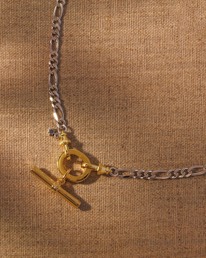 Mixed metal chain necklace with gold oval clasp and T-bar pendant charm attached to figaro chain