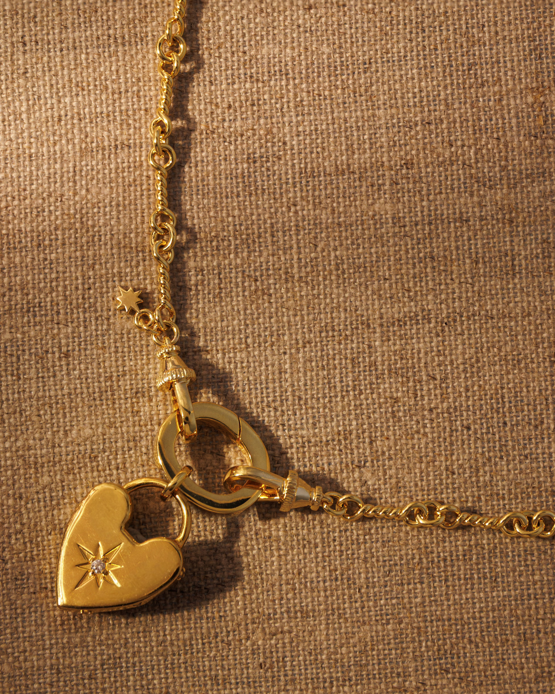 Raven James ROMY gold heart pendant on ARABELLA horsebit chain necklace, 18ct gold plated recycled brass engravable heart pendant set with antique-inspired star motif and central crystal
