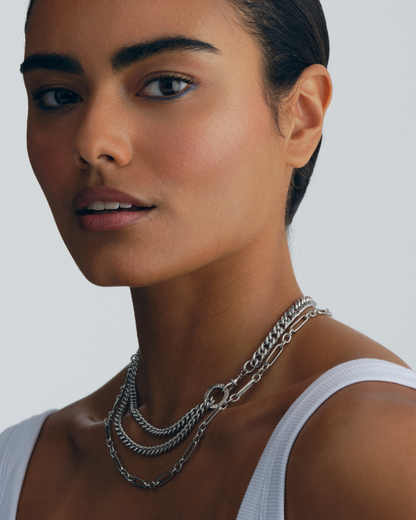 Multiple silver necklaces showing different chain styles and pendants