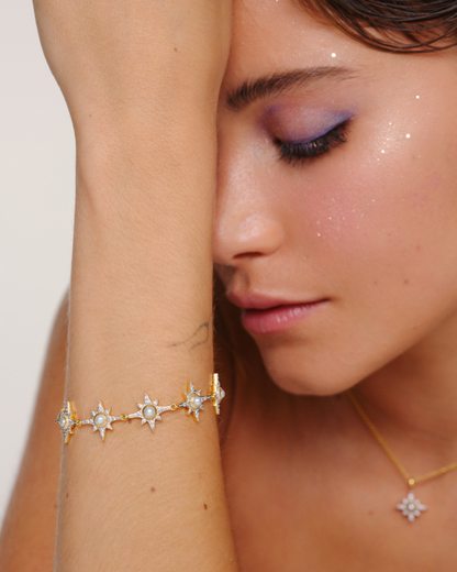 Model wearing Supernova pearl crystal bracelet with North Star pendant necklace in pearl with oval clasp and layering styling