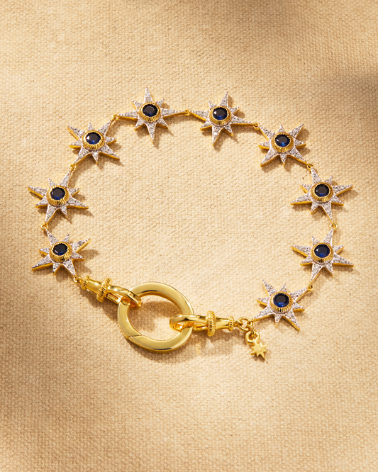 Supernova bracelet in gold with sapphire green crystals and star detailing, designed with oval clasp for multiway styling