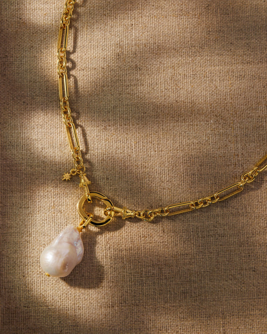 Gold paperclip chain and baroque pearl pendant. Antique-inspired demi-fine jewellery, built to layer, swap and wear your way.
