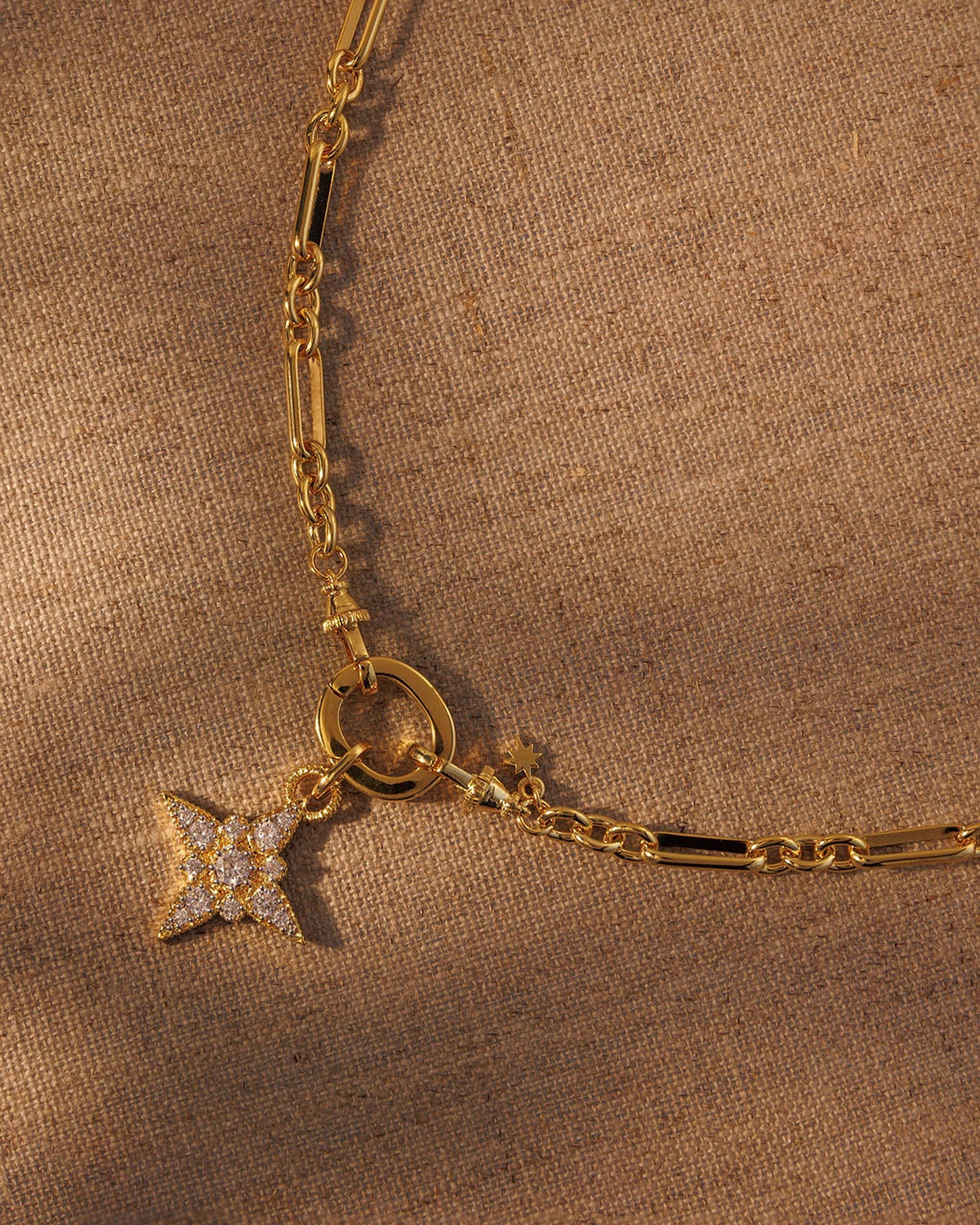 Gold paperclip chain necklace with crystal star pendant attached to clasp