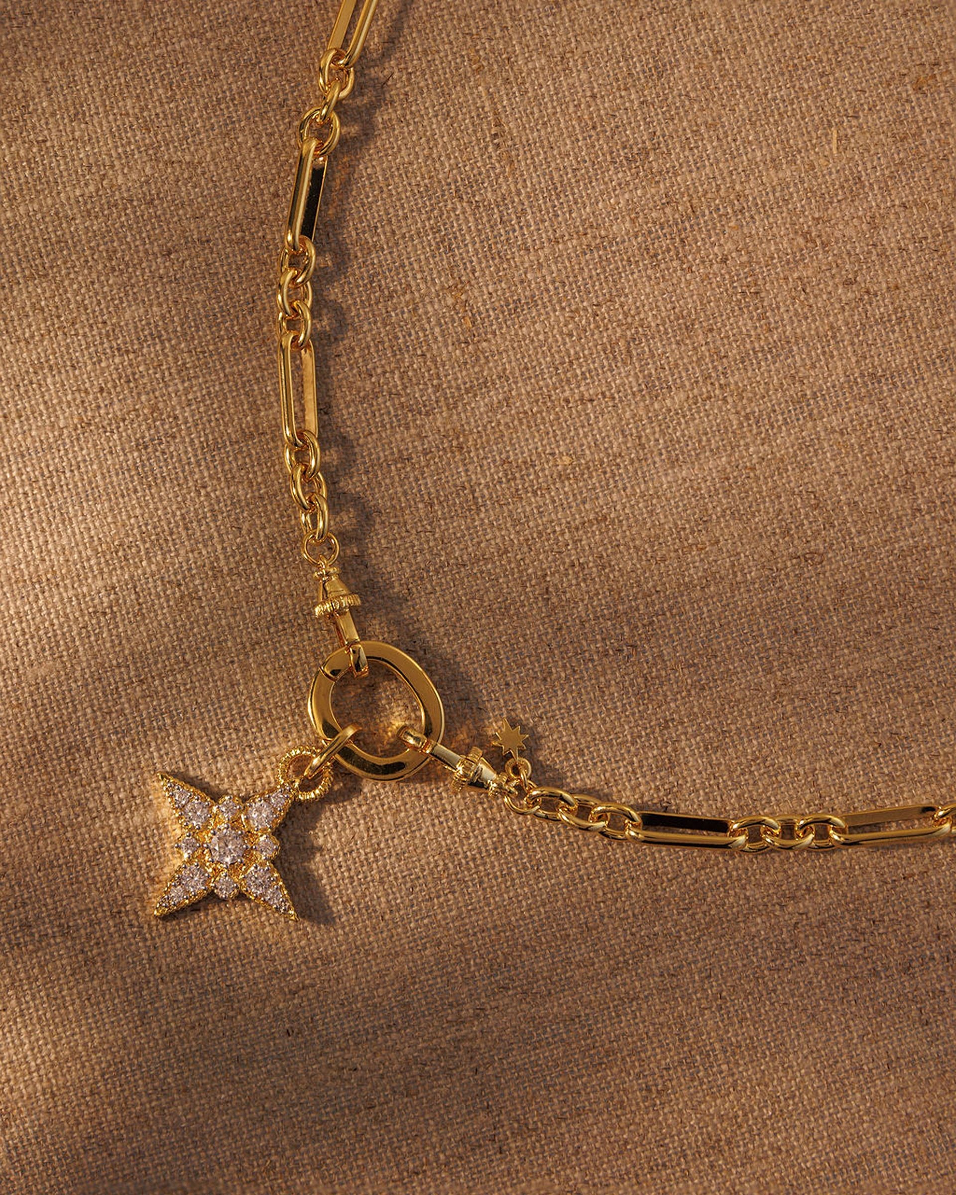 Gold paperclip chain necklace with crystal star pendant attached to clasp
