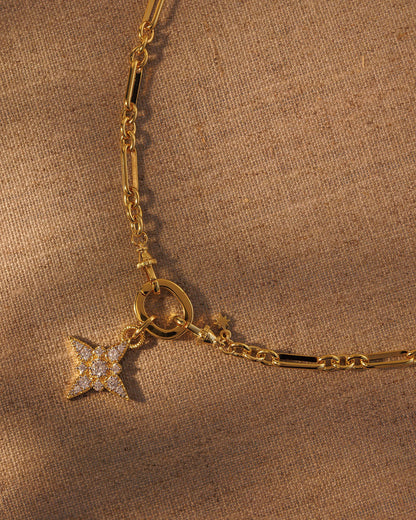 Gold paperclip chain necklace with crystal star pendant attached to clasp