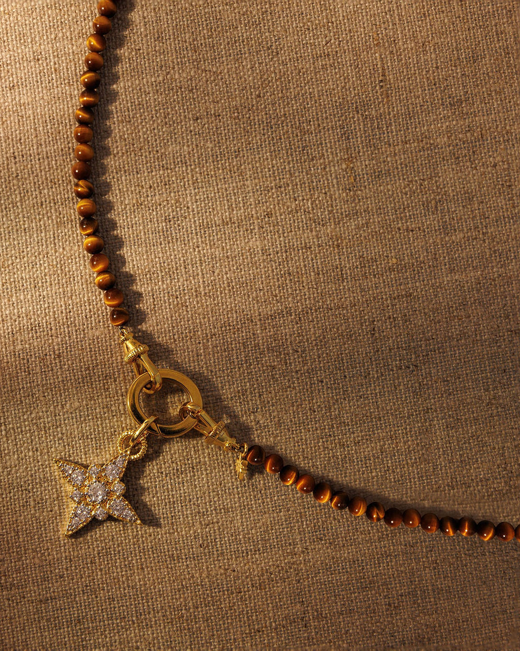 Tiger’s eye beaded necklace with gold crystal star pendant attached to oval clasp layered jewellery styling