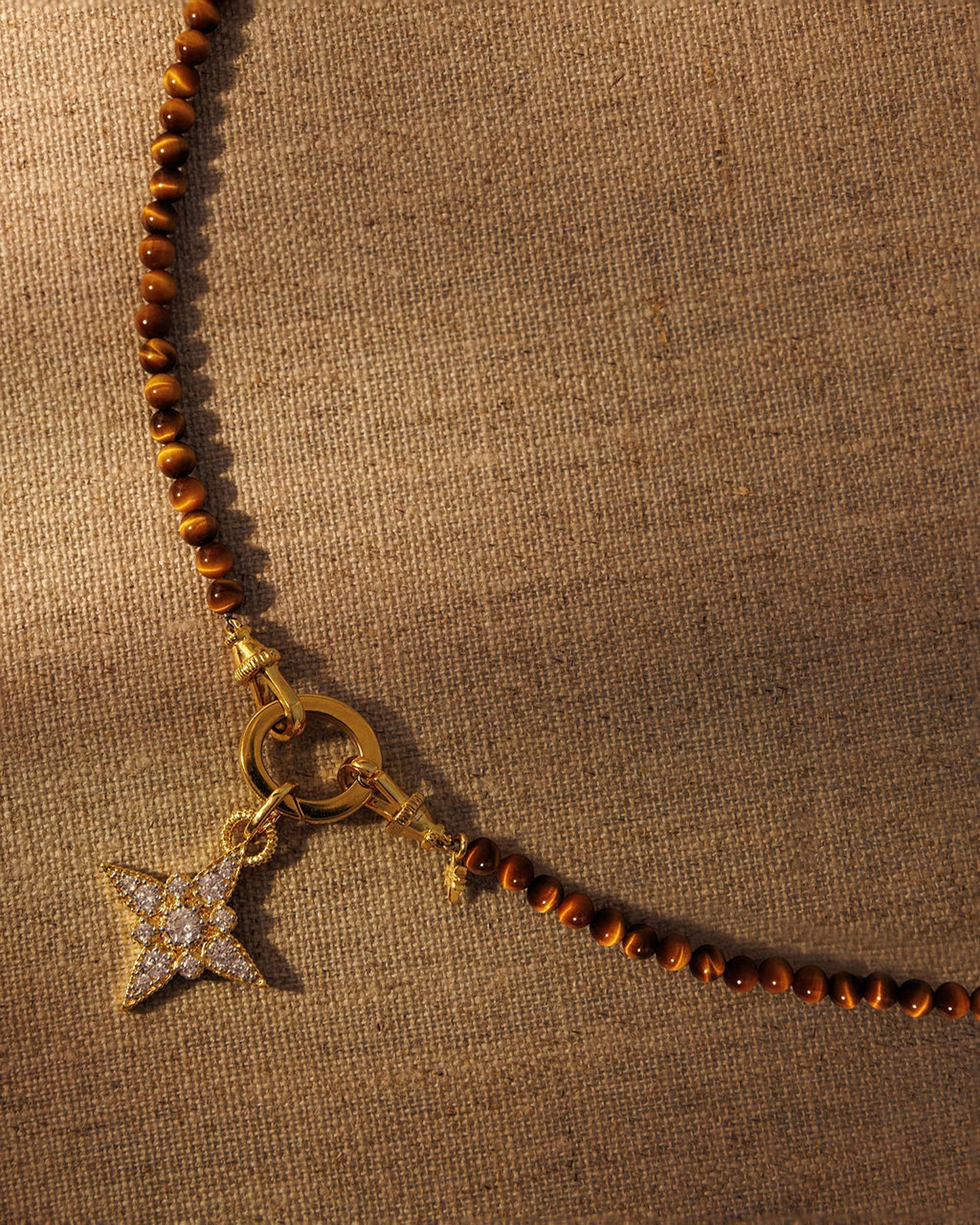 Tiger’s eye beaded necklace with gold crystal star pendant attached to oval clasp layered jewellery styling