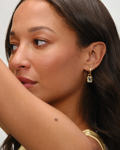 Cara reversible huggie hoop earrings styled with Lumi emerald cut green amethyst charm in 18ct gold