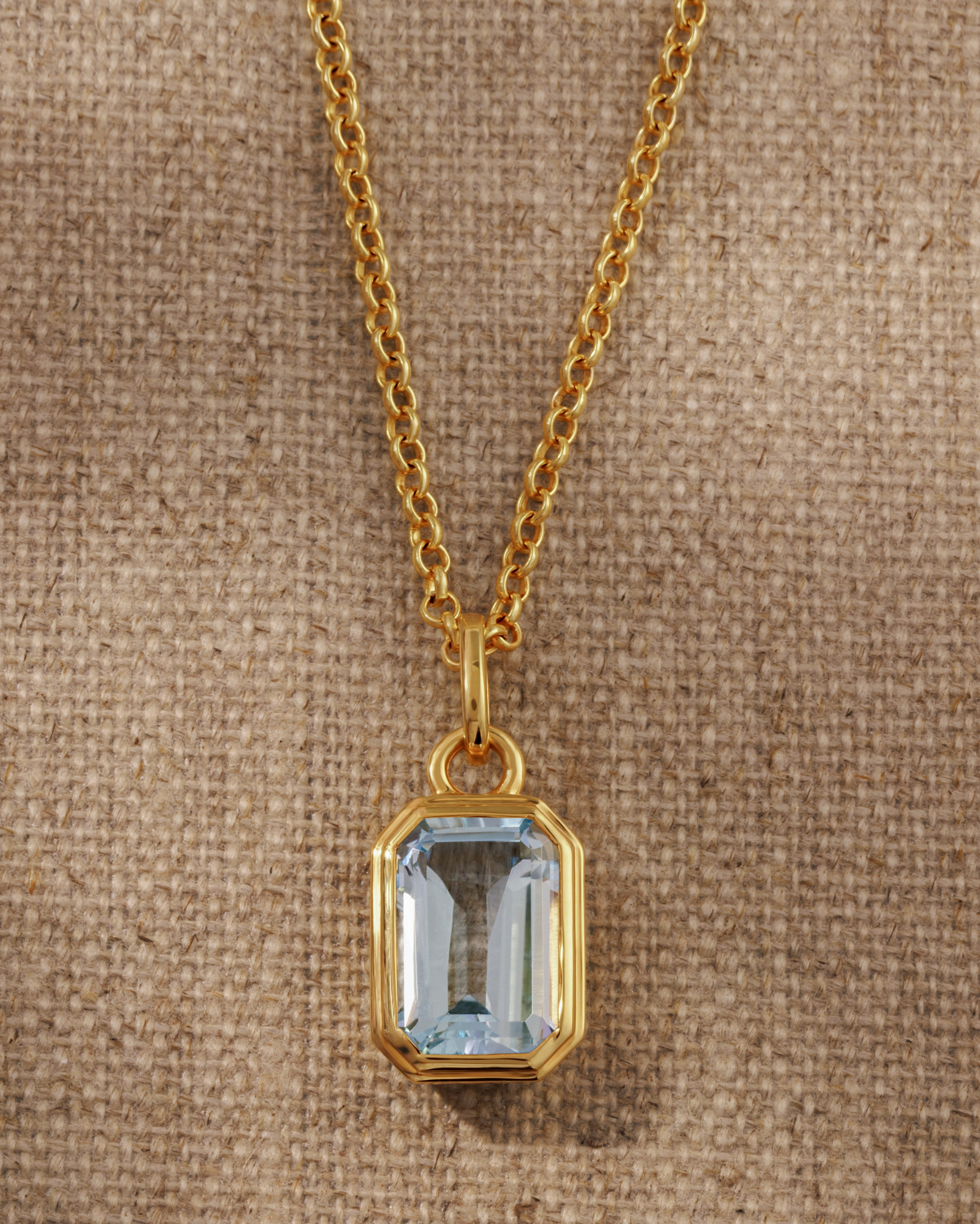 Lumi 18ct gold plated emerald cut blue topaz pendant on a layered gold chain necklace
