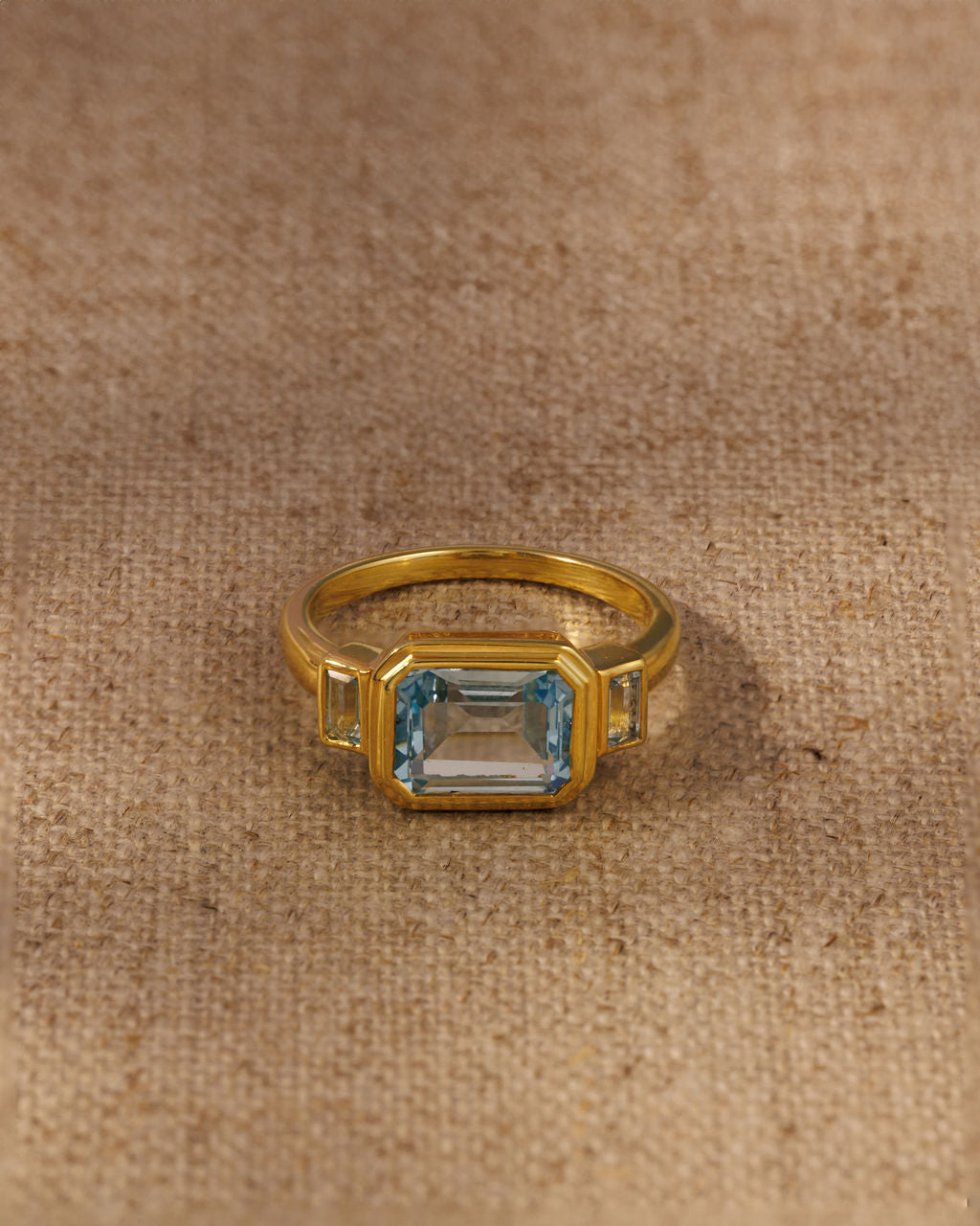 Lumi emerald cut blue topaz three stone ring in 18ct gold plated sterling silver