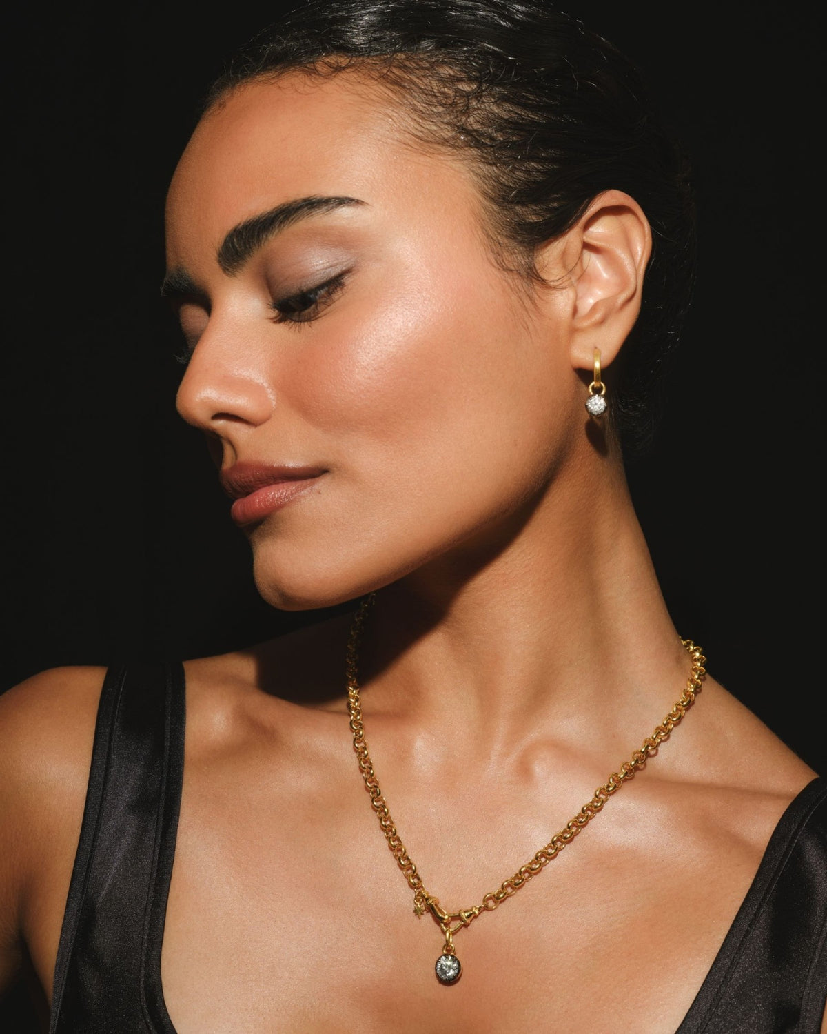 ODETTE round moissanite pendant on a gold belcher chain, worn with ODETTE earring charms