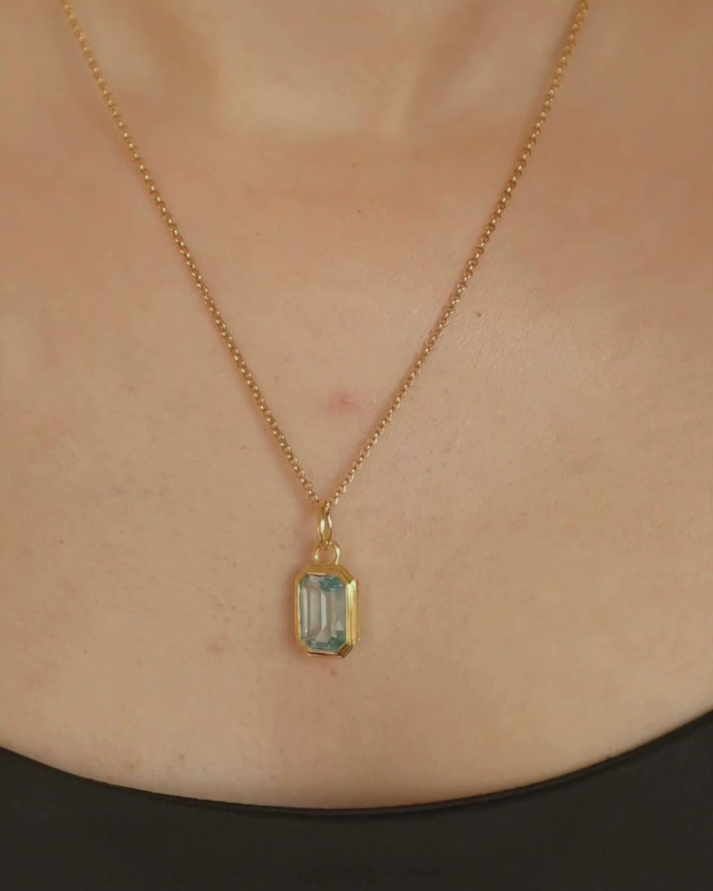 Lumi 18ct gold plated emerald cut blue topaz pendant styled on a gold chain necklace