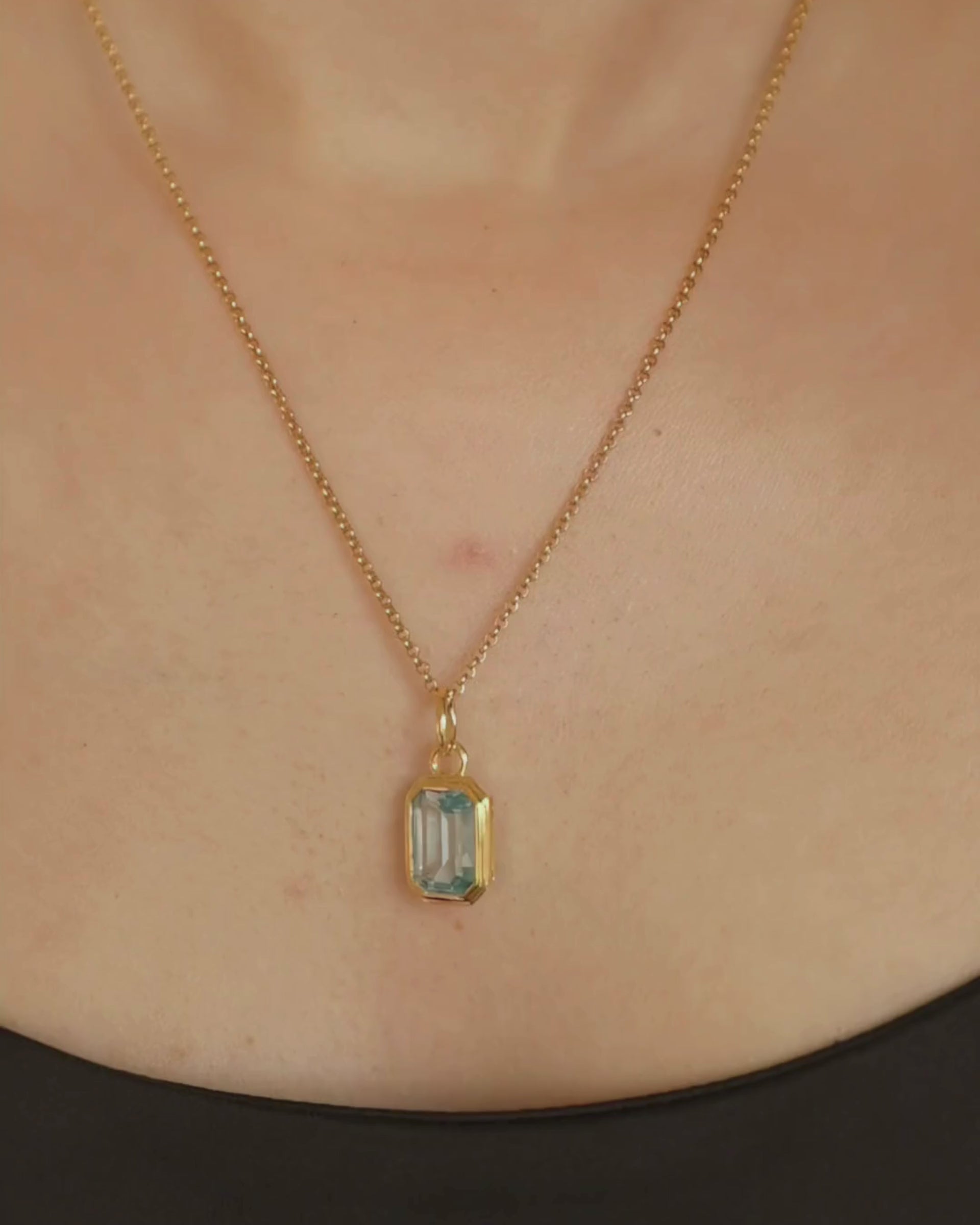 Lumi 18ct gold plated emerald cut blue topaz pendant styled on a gold chain necklace